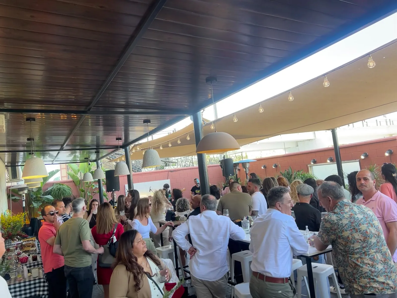 Mesas altas con invitados en un evento en Calizza